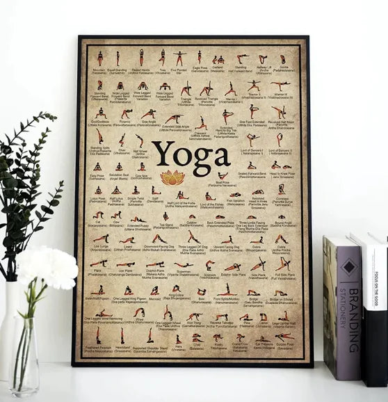 Yoga poster with various poses on a white surface with books and a plant. From ghg wellness shop.