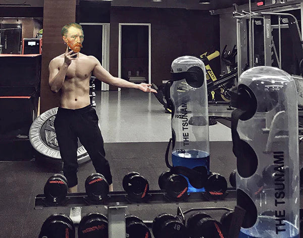 Person in a gym holding a bottle labeled 'The Tsunami' with weights in the foreground. Product from ghg global powerhouse.